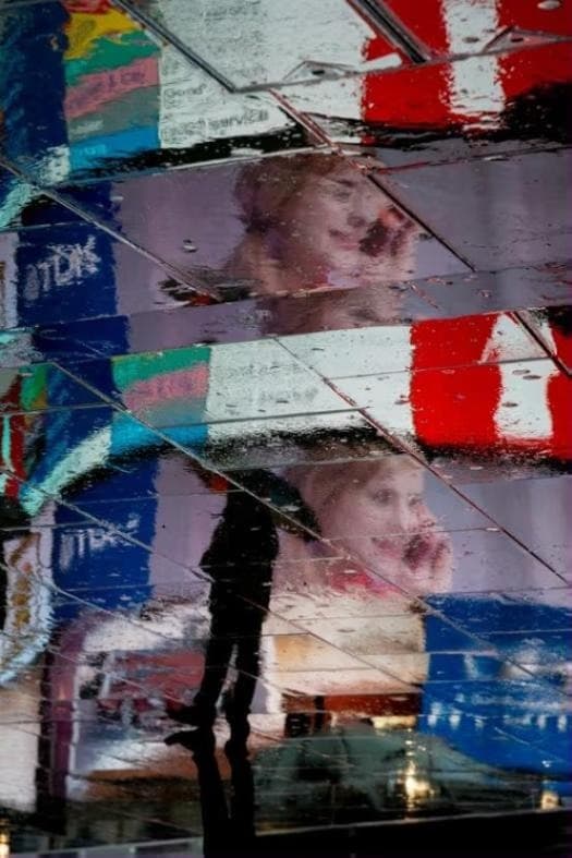 City billboards reflected on a wet pavement